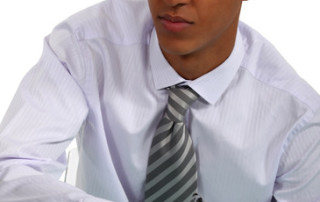 businessman on laptop writing on a piece of paper