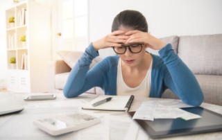 Worried young woman calculating debts
