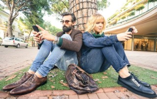 Millennial couple sitting down on the street