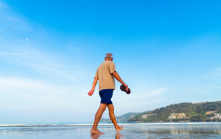 Old man walking on the beach