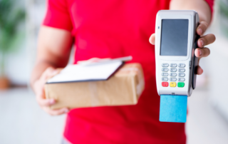 Delivery man holding parcel and POS